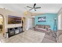 Spacious living room with neutral tile flooring, ceiling fan, and entertainment center with fireplace at 108 Orion Way, Sanford, FL 32773