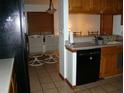 The kitchen flows into the dining area, showcasing tile flooring and a black dishwasher at 11624 Delmar Ave, Orlando, FL 32836
