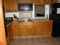 Classic kitchen features wood cabinets, tiled backsplash, and modern appliances including a black refrigerator at 11624 Delmar Ave, Orlando, FL 32836