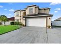 Two-story home featuring a well-manicured lawn, a two-car garage, and a neutral-colored facade at 12543 Waterhaven Cir, Orlando, FL 32828