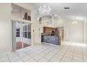 Open-concept living room featuring tile floors, a mosaic wet-bar, and an elegant chandelier at 12543 Waterhaven Cir, Orlando, FL 32828