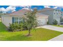 Single-story home with a well-manicured lawn and an attached two-car garage at 1312 Sugarwood St, Davenport, FL 33837