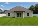 A view of the back exterior showing a well maintained lawn and covered patio at 13254 Sw 30Th Terrace Rd, Ocala, FL 34473