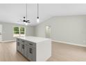 Modern kitchen featuring a central island with gray cabinets, quartz countertop, and pendant lighting at 13254 Sw 30Th Terrace Rd, Ocala, FL 34473