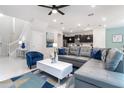Open-concept living room featuring a large gray couch, modern decor, and lots of natural light at 1820 Summer Dr, Davenport, FL 33897
