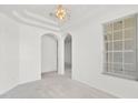 Bright living area with white walls, carpeted floor, modern lighting, and arched doorways at 212 Tavestock Loop, Winter Springs, FL 32708