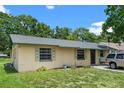 A cozy home exterior with green trim and mature trees in a relaxed neighborhood setting at 2213 Bates Ave, Eustis, FL 32726