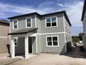 Two-story home featuring gray siding, white trim, and covered front porch and large windows at 2467 Zuni Road, St Cloud, FL 34771
