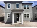 Two-story home featuring gray siding, white trim, and covered front porch with great curb appeal at 2467 Zuni Road, St Cloud, FL 34771