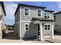 Two-story home featuring gray siding, white trim, and covered front porch and large windows at 2467 Zuni Road, St Cloud, FL 34771