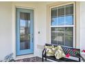 Welcoming front entrance featuring a stylish glass door, bench seating, and vibrant floral accents at 2766 Purple Meadow Ct, Minneola, FL 34715
