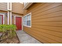 Townhome exterior featuring a red door, bright window, and landscaped walkway at 318 Australian Way, Davenport, FL 33897