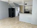 Open-concept living area with tile floors, a breakfast bar, and an adjacent kitchen at 4001 San Sabastian Dr # 107, Kissimmee, FL 34741
