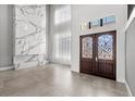 Grand entryway featuring elegant double doors, soaring ceilings, and a striking marble accent wall at 4047 Isabella Cir, Windermere, FL 34786
