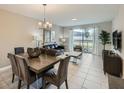 Cozy living and dining space with neutral tones, modern decor, and sliding glass doors to outdoor area at 4731 Clock Tower Dr # 104, Kissimmee, FL 34746