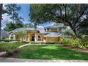 Charming home featuring a black front door, arched windows and lush, manicured landscaping at 4819 Shoreline Cir, Sanford, FL 32771