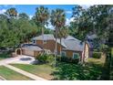 Spacious two-story home featuring a large lawn and mature trees, with a side-entry garage at 4819 Shoreline Cir, Sanford, FL 32771
