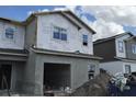 New construction home featuring an attached garage and partially finished exterior under a cloudy sky at 5103 Prairie Preserve Run, St Cloud, FL 34772
