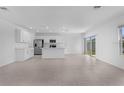 An expansive kitchen features white cabinets, stainless steel appliances, tile floors, and a central island with backyard views at 5109 Forget Me Not Ave, Lake Hamilton, FL 33851