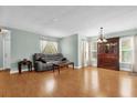 Open living space with hardwood flooring, gray sofa, and entertainment center at 5452 E Michigan St # 7, Orlando, FL 32812