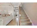 Inviting foyer with staircase, tile floors, and view into a beautifully furnished living room at 5489 Baldwin Park St, Orlando, FL 32814