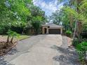 Single-story home with lush landscaping, long driveway, and an attached two-car garage at 670 N Sparkman Ave, Orange City, FL 32763