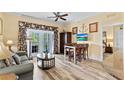 Inviting living room featuring hardwood floors, comfortable seating, and a seamless flow into the kitchen area at 7630 Heritage Crossing Way # 302, Reunion, FL 34747