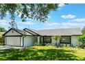 A cozy single-story home featuring well-maintained landscaping, an attached garage, and a manicured lawn at 7664 Clubhouse Estates Dr, Orlando, FL 32819