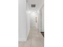 Hallway with tile floors, white walls, and multiple doorways leading to various rooms in the home at 7664 Clubhouse Estates Dr, Orlando, FL 32819