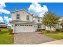 Charming two-story home featuring a paver driveway, two-car garage, and well-maintained landscaping at 9034 Stinger Dr, Davenport, FL 33896