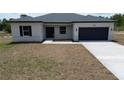 Inviting single-story home featuring a minimalist design, complemented by fresh landscaping and a concrete driveway at 13253 Sw 83Rd Cir, Ocala, FL 34473