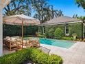 Inviting backyard pool area with stylish outdoor seating, lush greenery, and a charming pool house at 1400 Place Picardy, Winter Park, FL 32789