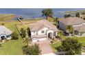 Beautiful aerial view of landscaped home with dock on the water and manicured lawn at 16054 Johns Lake Overlook Dr, Winter Garden, FL 34787