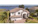 Stunning aerial view of a two-story home with a three-car garage that is located on the water at 16054 Johns Lake Overlook Dr, Winter Garden, FL 34787