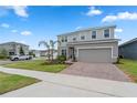 Charming two-story home with lush front lawn and brick paved driveway at 1616 Eucalyptus Way, Davenport, FL 33837