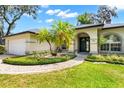 Beautiful home featuring well-manicured landscaping and a covered front entryway at 169 Winding Oaks Ln, Oviedo, FL 32765
