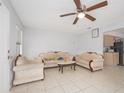 Inviting living room featuring neutral-toned furniture, tile flooring, and a ceiling fan at 1708 Nebraska Ave, Kissimmee, FL 34744