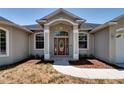 Inviting front entrance featuring a decorative glass door, large windows, and manicured landscaping at 2300 Dawnwood Ln, Orlando, FL 32809