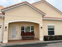 Front view of the home showcasing a charming entrance and manicured landscaping with bench at 2612 Shantiniketan Blvd # G12, Tavares, FL 32778