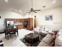 Spacious living room featuring tile flooring and a kitchen with modern stainless appliances at 2612 Shantiniketan Blvd # G12, Tavares, FL 32778
