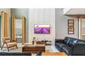 Cozy living room featuring stylish decor, high ceilings, a textured accent wall, and comfortable seating at 2791 Punctuation Pl, Kissimmee, FL 34746