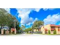 Community entrance with mature trees, manicured landscaping, and well-maintained buildings at 2810 N Powers Dr # 59, Orlando, FL 32818