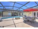 Screened-in pool area with ample seating, a dining table, and a fire pit, perfect for outdoor entertaining at 2850 Babylon Ct, Oviedo, FL 32765