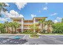 Attractive condominium building with tropical landscaping, ample parking, and private balconies for each unit at 304 Rum Run # 304, Davenport, FL 33897