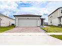 Single-Gathering home with a brick-paved driveway, two-car garage, and well-maintained landscaping at 30498 Pintail Dr, Leesburg, FL 34748
