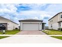 Single-Gathering home with a brick-paved driveway, two-car garage, and well-maintained landscaping at 30498 Pintail Dr, Leesburg, FL 34748