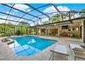 Inviting screened-in pool area with ample seating, outdoor dining, and a built-in bar for relaxing and entertaining at 311 Needles Trl, Longwood, FL 32779
