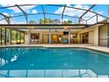 Stunning pool with a screened enclosure, outdoor seating, dining area, and a built-in grill for entertaining at 311 Needles Trl, Longwood, FL 32779