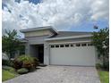 Elegant single-story home featuring a well-manicured lawn, brick driveway, and a two-car garage at 3397 Sagebrush St, Harmony, FL 34773