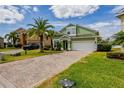 Two-story home featuring a brick driveway, lush lawn, and tasteful landscaping at 344 Cadiz Loop, Davenport, FL 33837